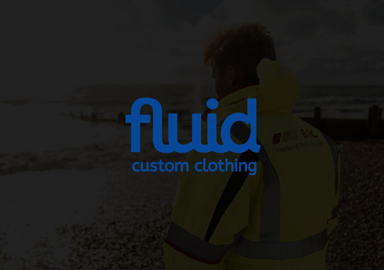 Person in a bright yellow jacket overlooks a beach, with "fluid custom clothing" logo displayed.
